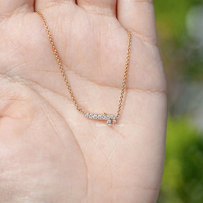 Gold-tone initial pendant necklace shown on an open palm, close-up.