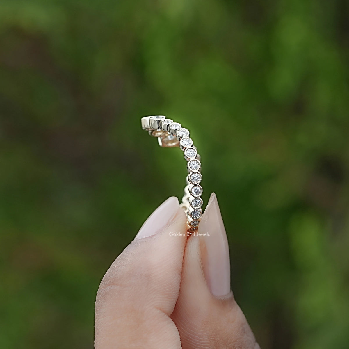 Curved eternity band profile with round stones and shared prong-style setting