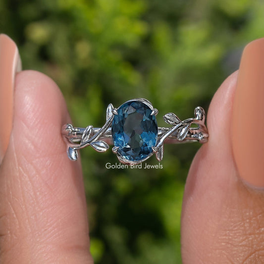 Oval blue gemstone leaf-style ring in Argentium silver, openwork prongs
