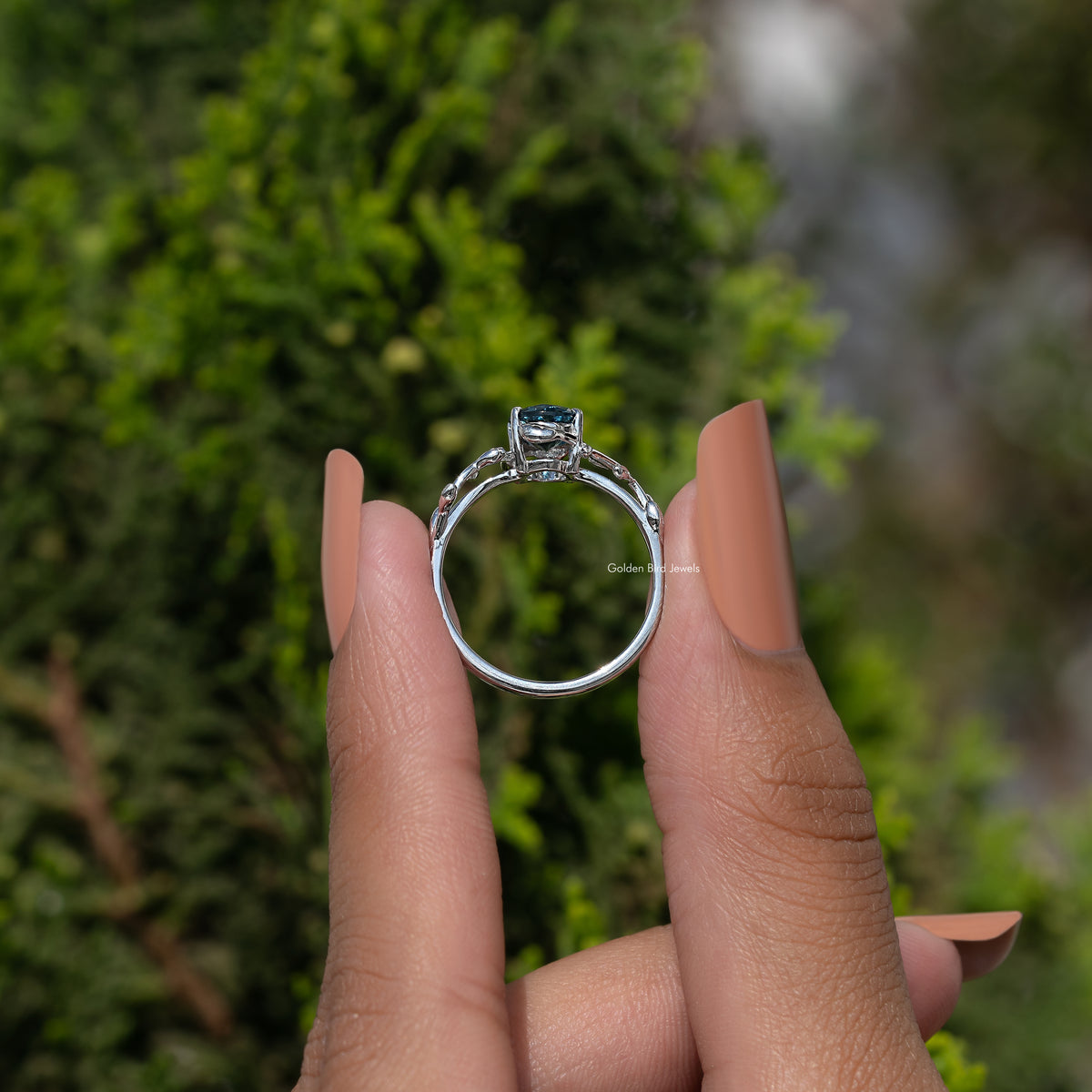 Argentium silver ring with oval blue center, open gallery back and leaf prongs