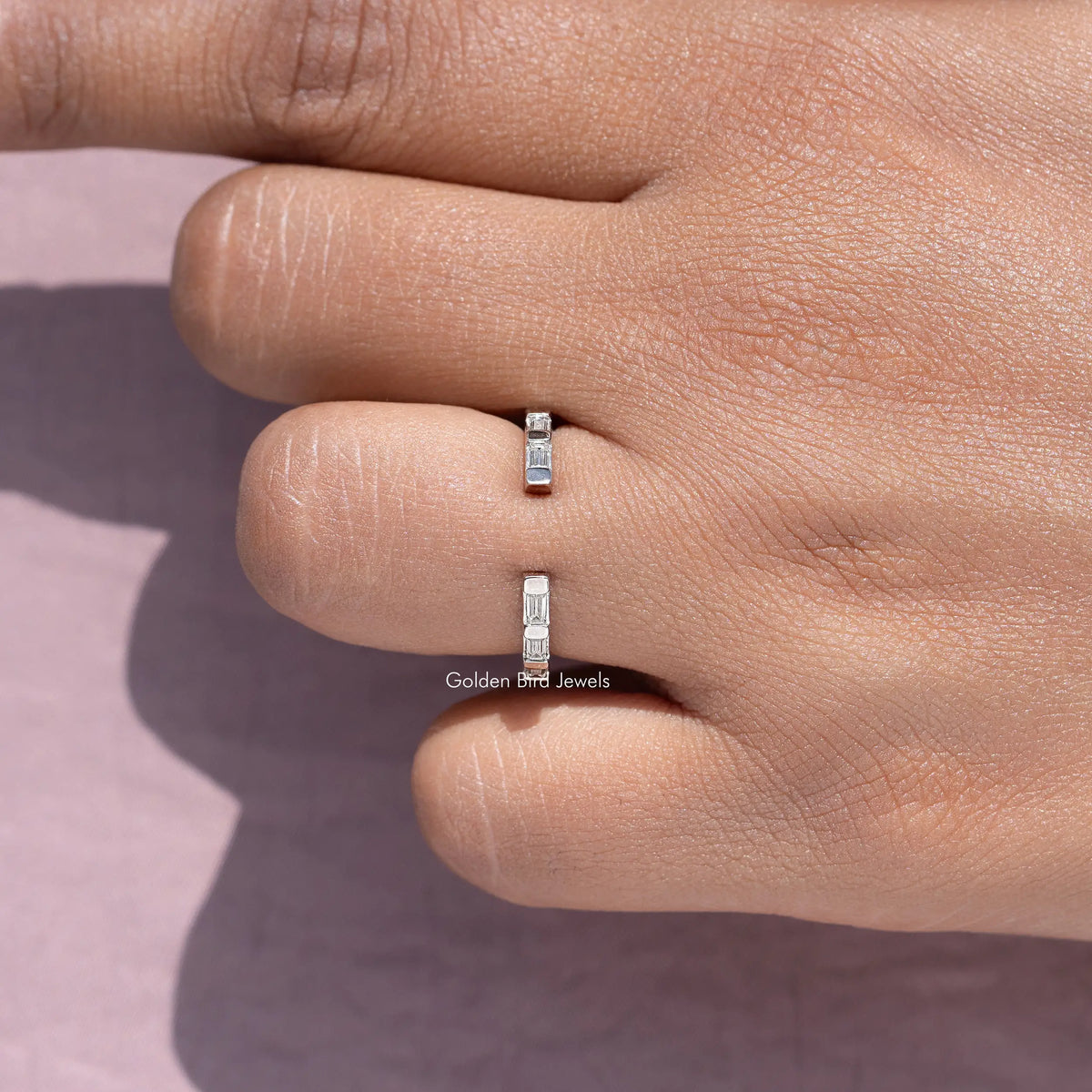 Silver baguette open-gap ring band on fingertip, bar-set moissanite stones