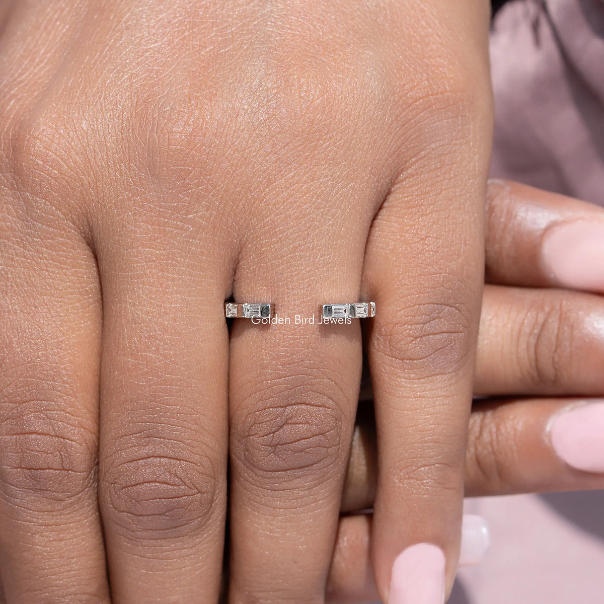 Silver open-gap proposal band ring with baguette stones, close-up on fingers