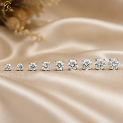 Round moissanite solitaire stud earrings with small round stones, in a straight row.