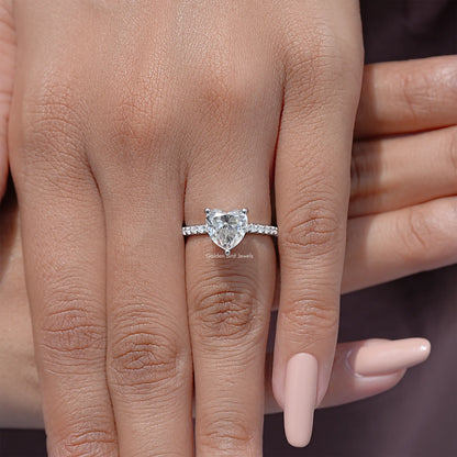 Heart-shaped moissanite solitaire ring with silver prong band on hand