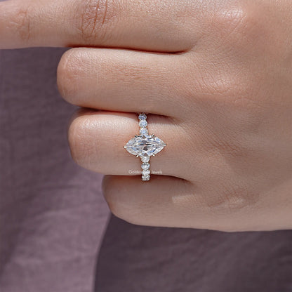 Moissanite ring on finger with marquise-cut center stone and small halo accents