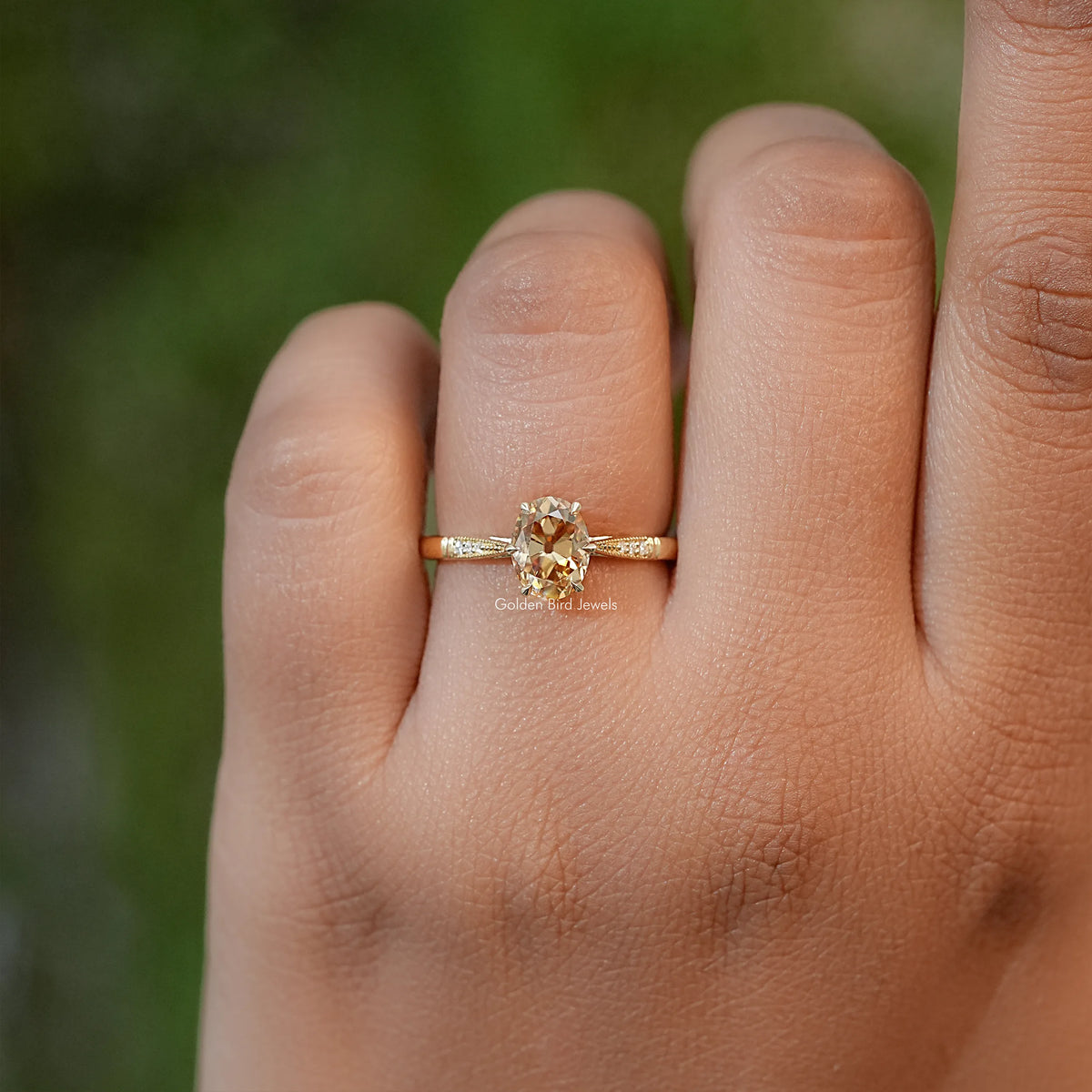 Oval moissanite solitaire engagement ring with slim gold band and small side stones