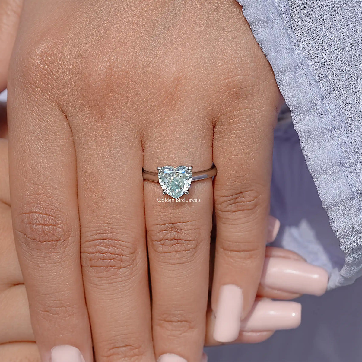Sterling silver solitaire ring on finger, faceted gemstone center setting