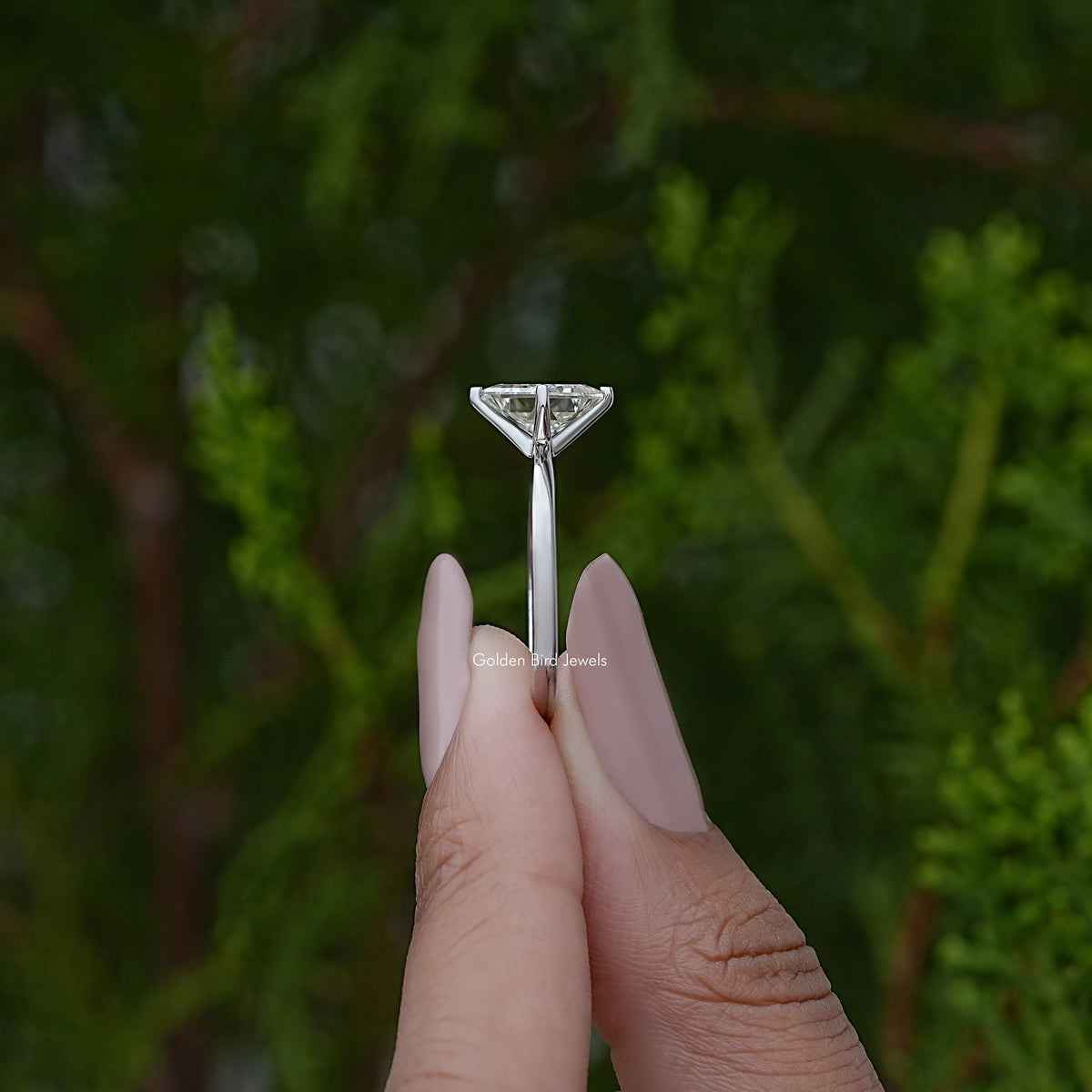 Side view of princess-cut solitaire engagement ring with tapered prongs and silver band