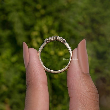 Curved wedding band ring viewed from front, baguette-cut stones set around top