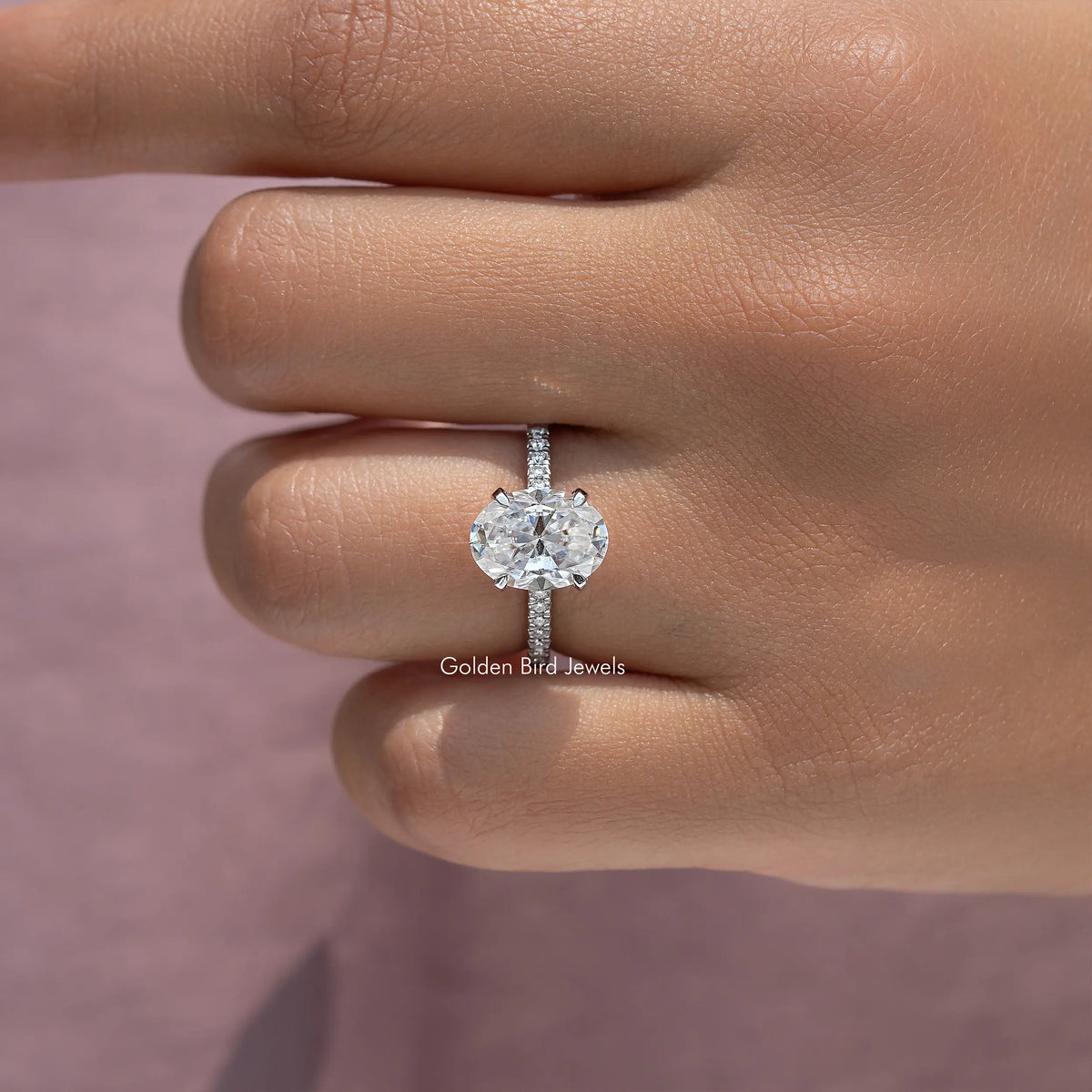 Oval-cut moissanite engagement ring with thin pave band, close side view