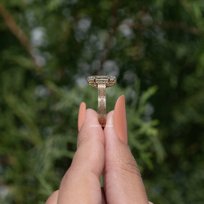 Marquise-style solitaire ring showing prong basket and patterned gold-toned band top view