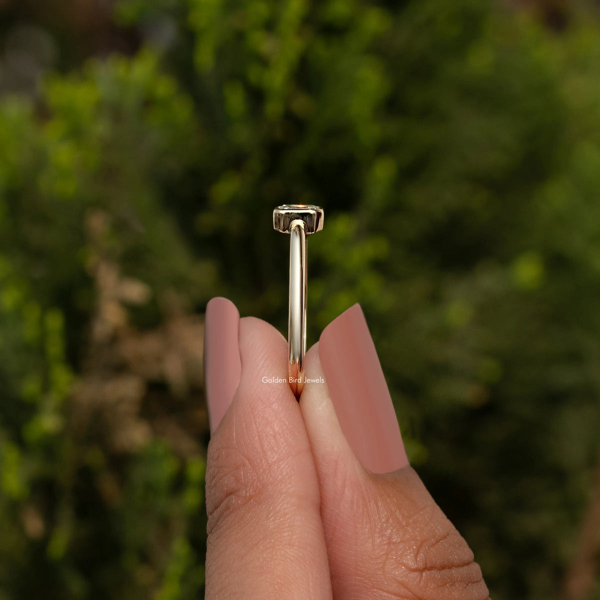 Gold-tone ring top view with emerald-cut lab diamond prong-set on a slim band