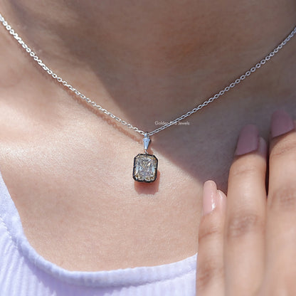 Square-cut moissanite solitaire pendant on silver chain near fingers