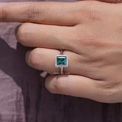 Square teal moissanite ring in sterling silver, close-up on finger