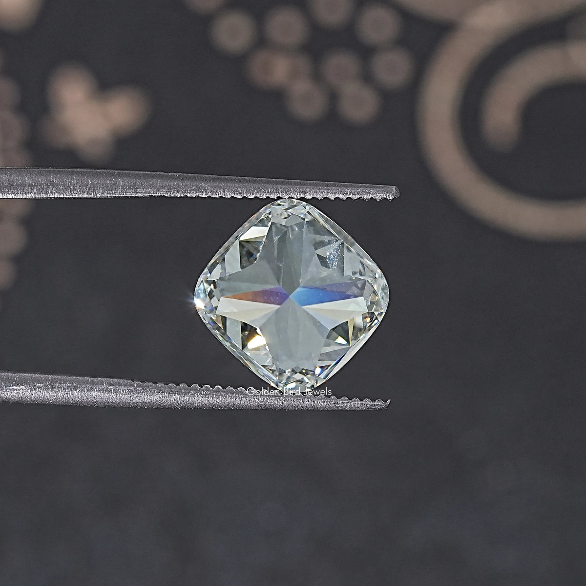 Loose cushion-cut lab diamond on tweezers, close-up of table and facets