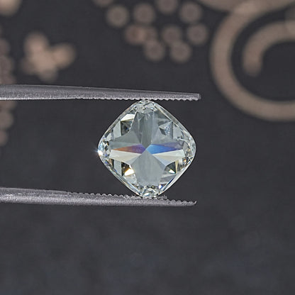 Loose cushion-cut lab diamond on tweezers, close-up of table and facets