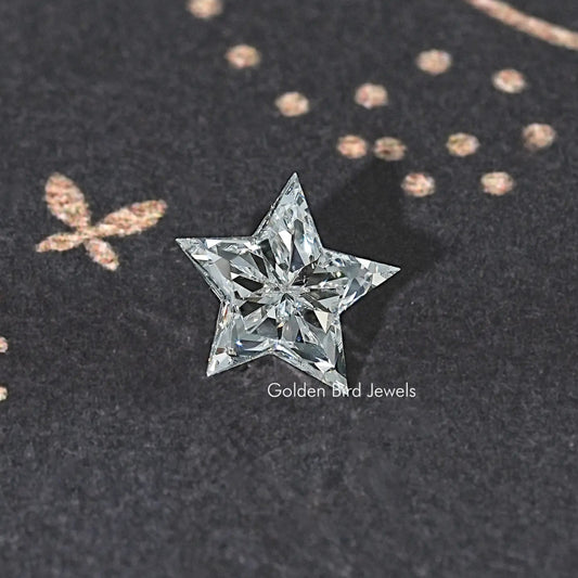 Star-cut lab diamond with clear faceted sparkle on dark fabric surface
