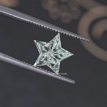 Star-cut lab diamond with bright facets, shown in metal tweezers