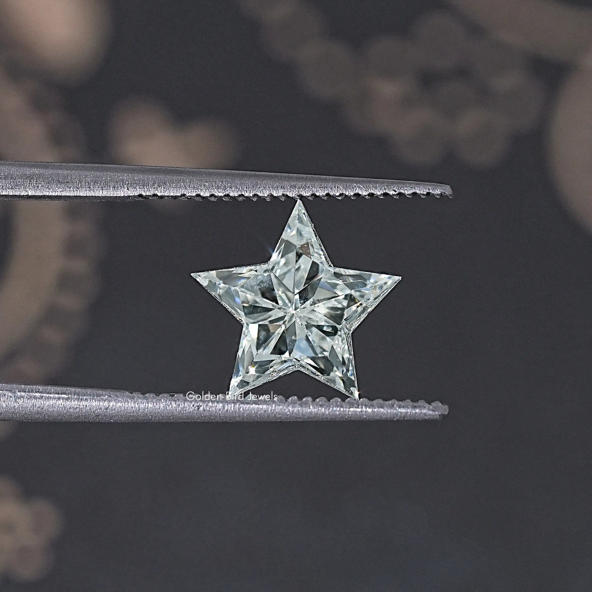 Star-cut lab diamond with crisp facets, held between two metal bars