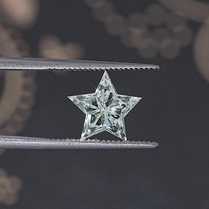 Star-cut lab diamond with crisp facets, held between two metal bars