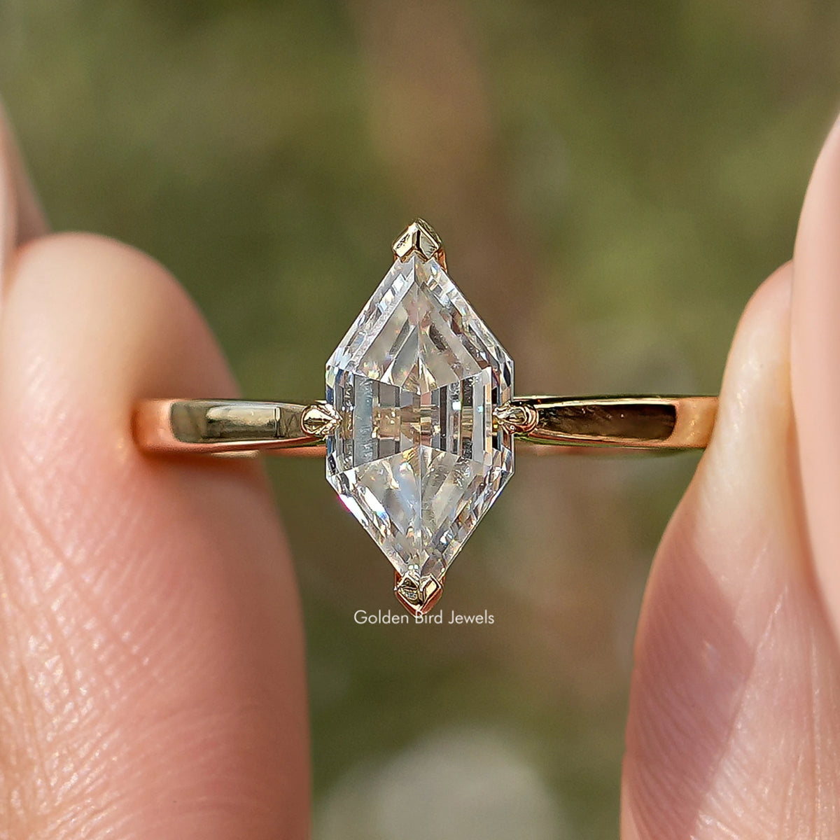 Gold-tone ring with large marquise step-cut moissanite, detailed prong setting