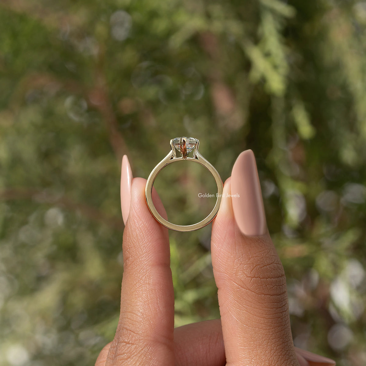Gold-tone ring showing marquise step-cut moissanite from behind, open band