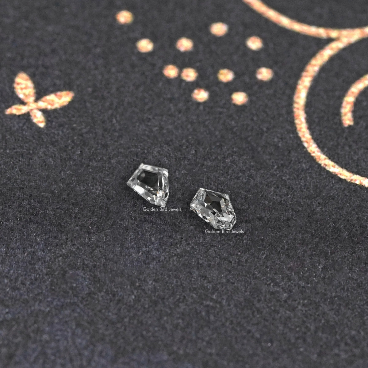 Pair of step-cut lab-grown diamonds with sharp, angled faceting.