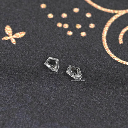 Pair of step-cut lab-grown diamonds with sharp, angled faceting.