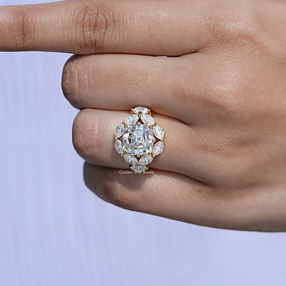 14K yellow gold halo engagement ring on finger with step-cut center stone