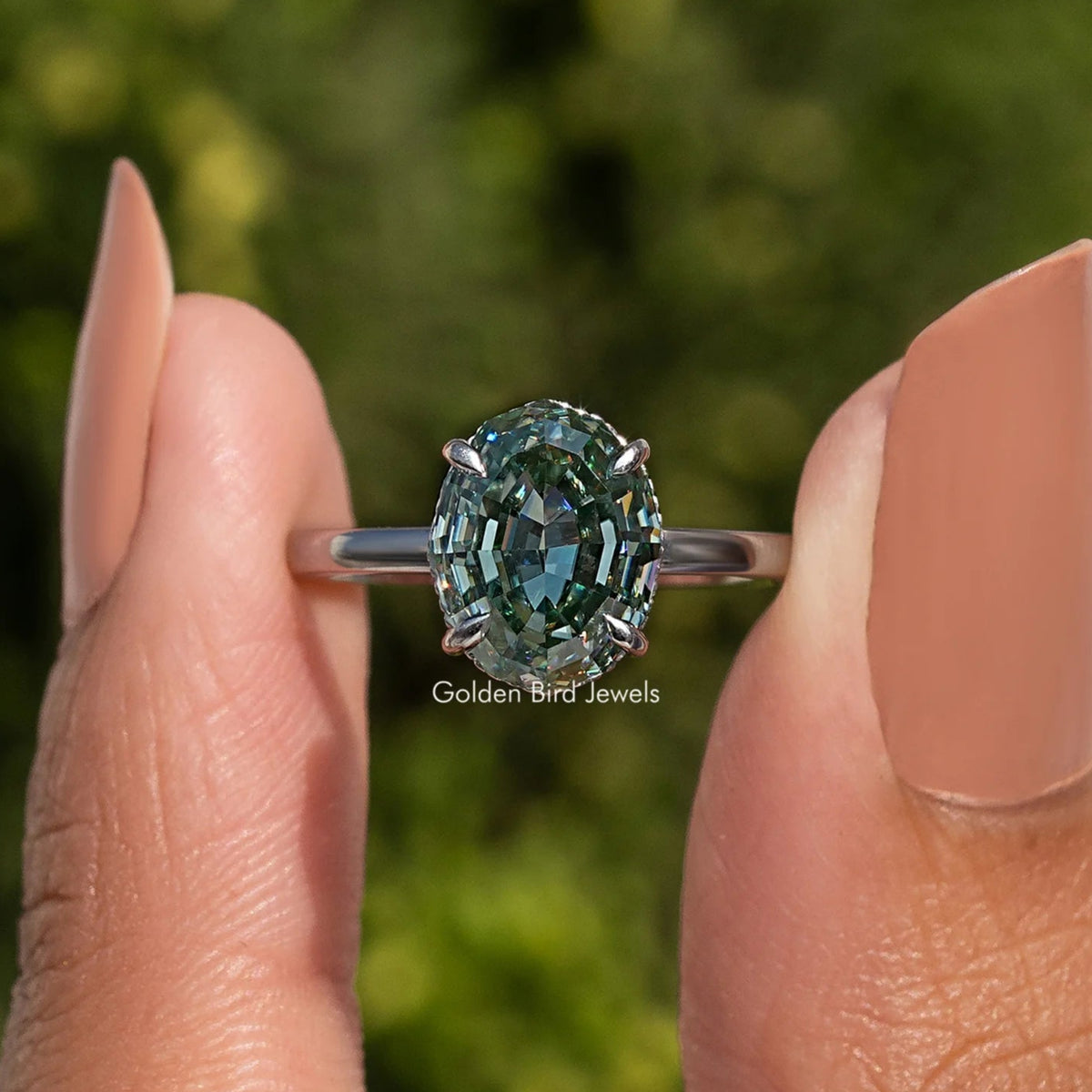 Oval step-cut solitaire ring in sterling silver with hidden halo and teal gemstone front view