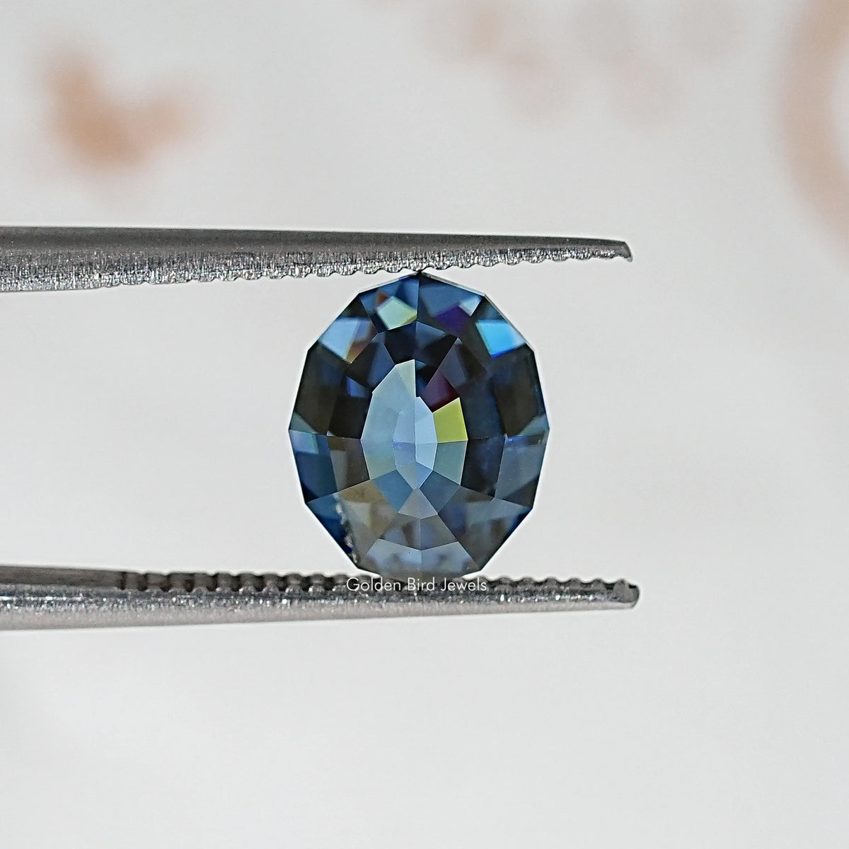 Loose step-cut oval blue moissanite gemstone with vivid blue facet flashes
