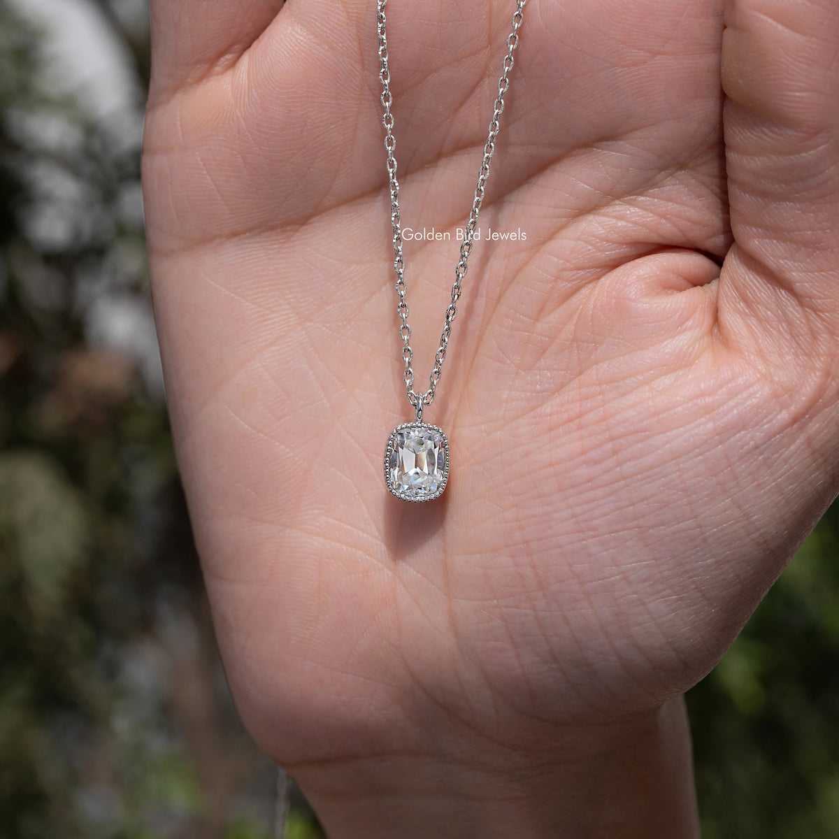 Cushion-cut moissanite solitaire pendant necklace with silver chain, close-up