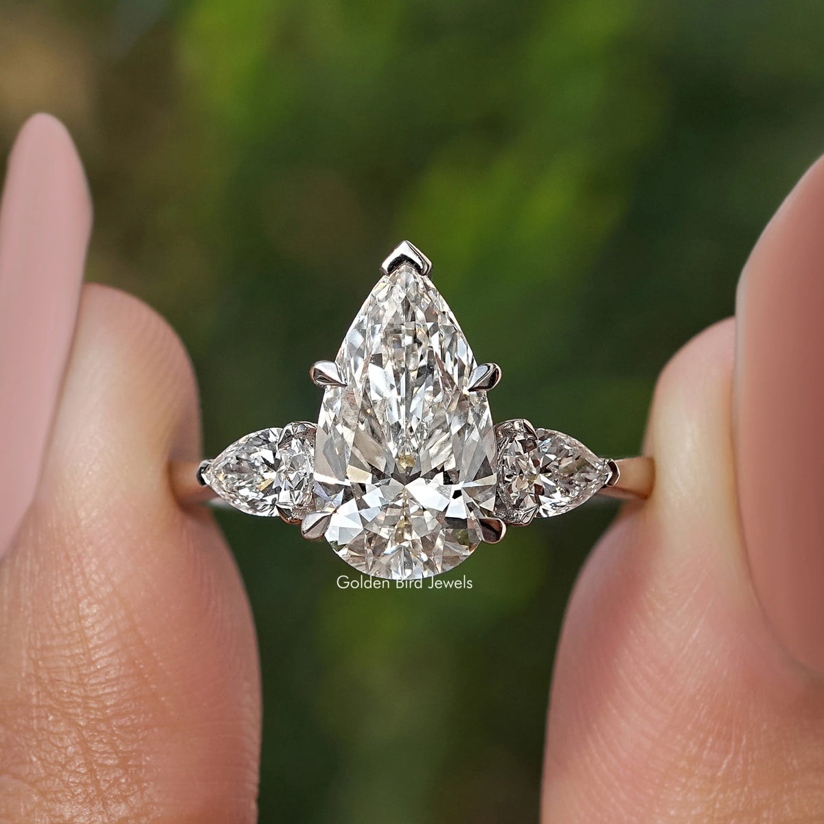 Three-stone pear-cut diamond engagement ring, large center pear with two side diamonds