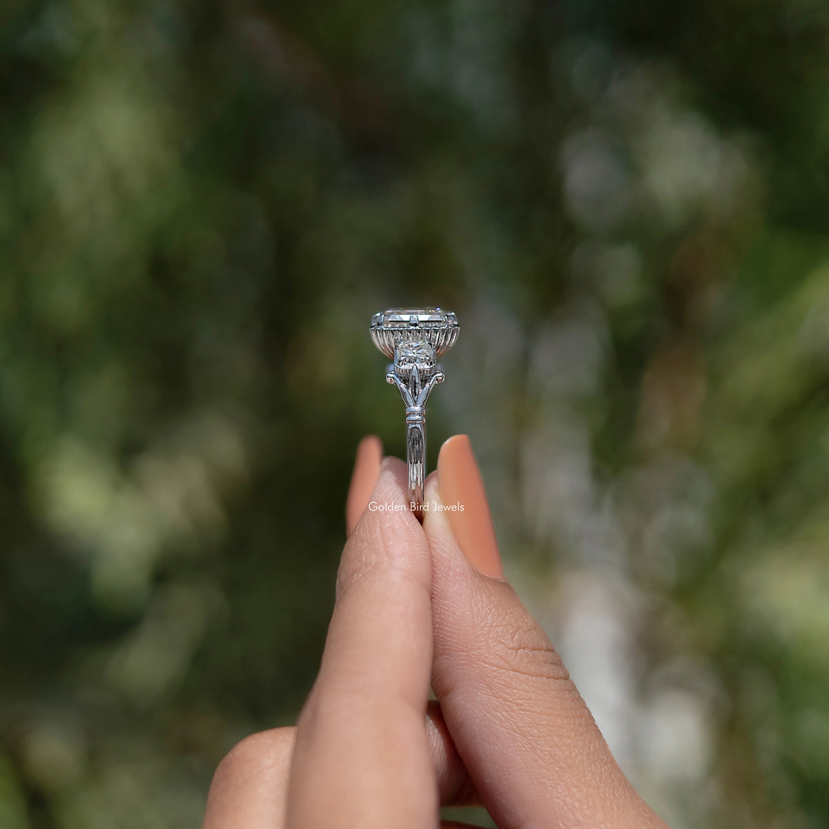 Three-stone moissanite ring with Asscher-cut center, raised prong setting