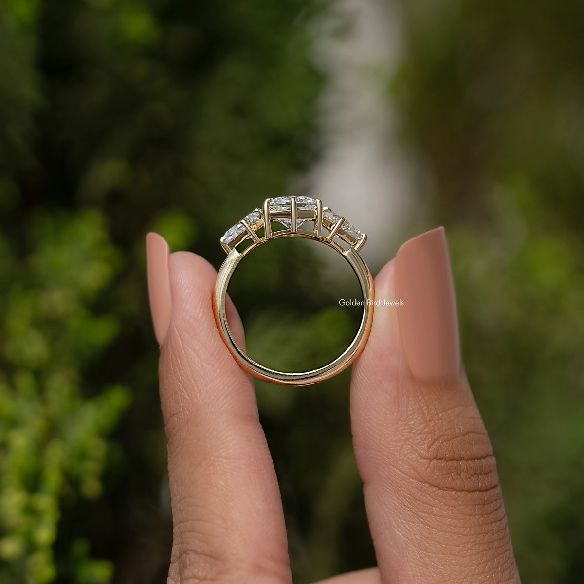 Three-stone diamond ring underside view with prong settings and open band, yellow gold