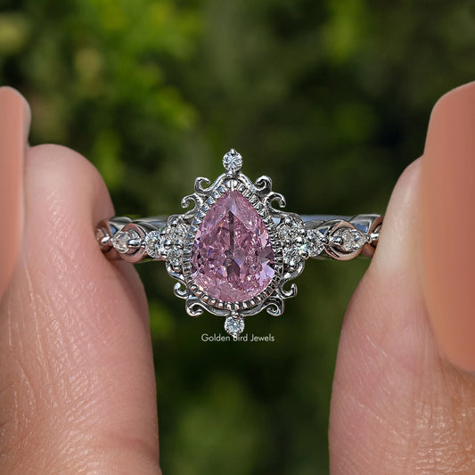 Argentium silver ring with large pear-shaped pink center stone and ornate side motifs