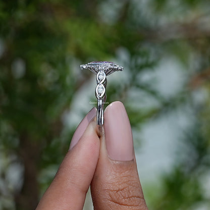 Silver-tone ring band with pink pear-cut gemstone, side profile view
