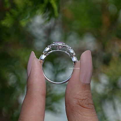 Tourmaline pink pear-cut gemstone ring in silver tone, side view held between fingers