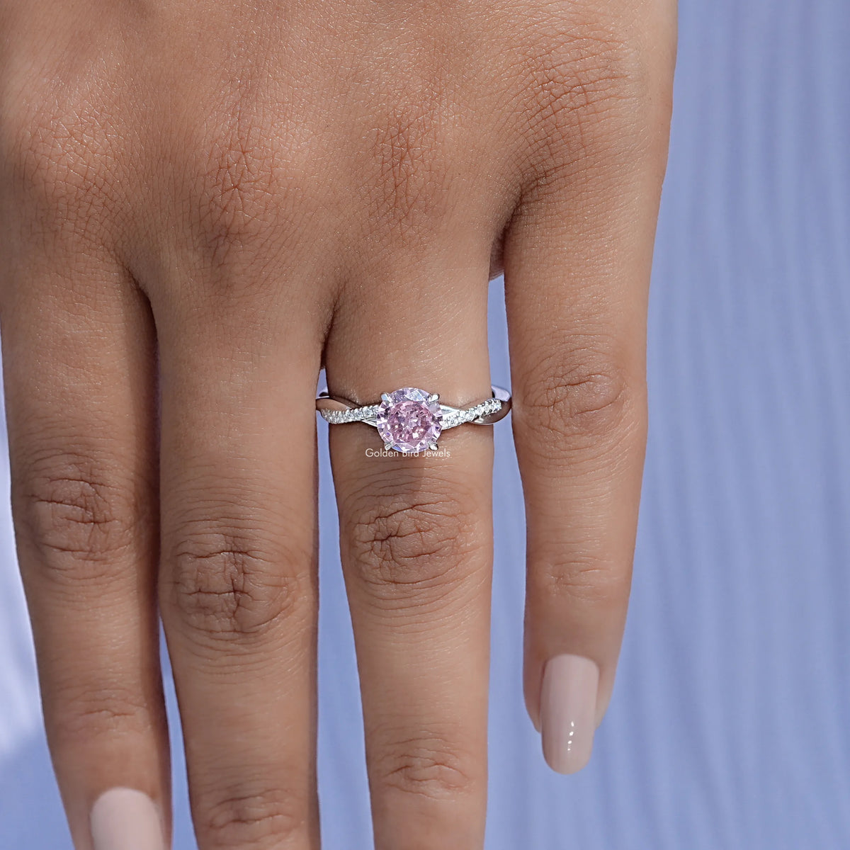 Pink tourmaline accent ring with round pink center stone and silver band