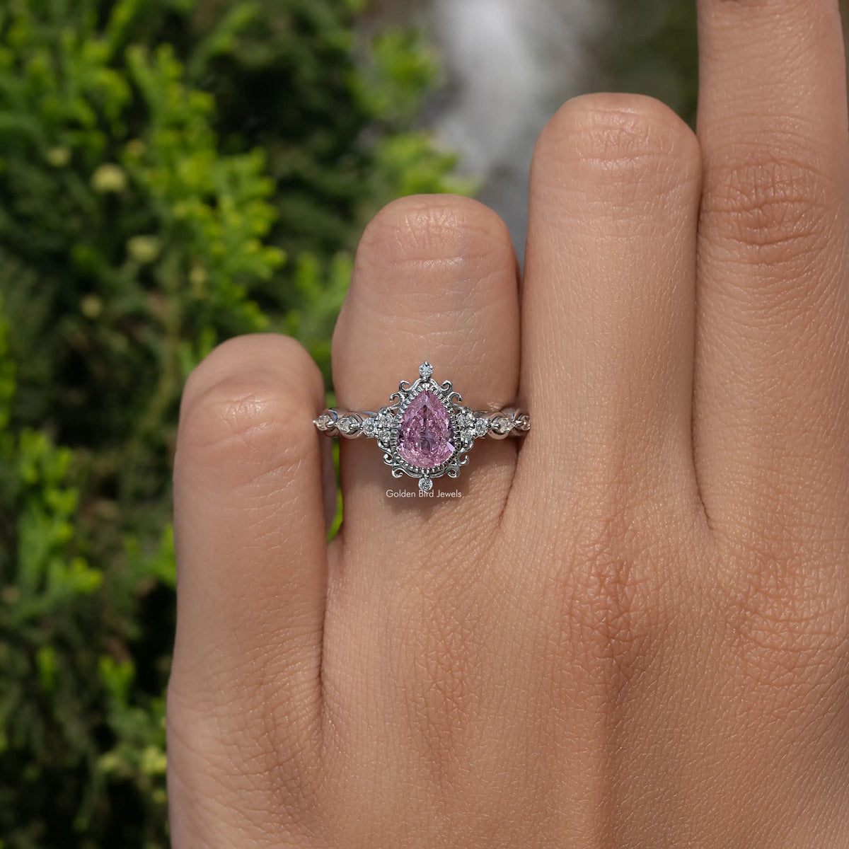 Argentium silver ring with pear-shaped pink gemstone and braided band, close-up