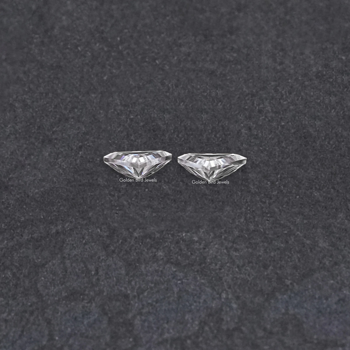 Pair of triangular moissanite stones, clear faceted close-up