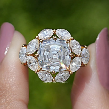 Close-up of step-cut center moissanite with round halo and gold-tone setting prongs