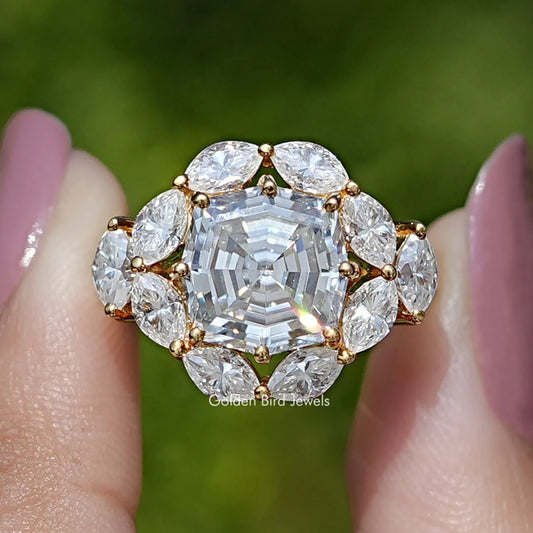 Close-up of step-cut center moissanite with round halo and gold-tone setting prongs
