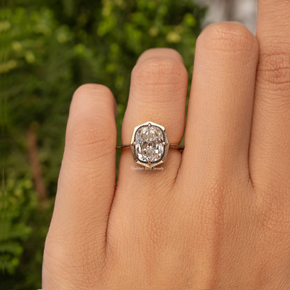 Gold-tone cushion-cut bezel set engagement ring on finger, vintage halo detail