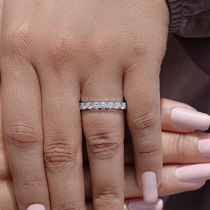Half eternity moissanite band with clear round-cut stones on hand, centered view