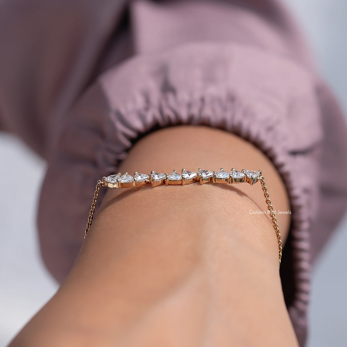Gold diamond line bracelet with marquise-cut stones on wrist, profile view
