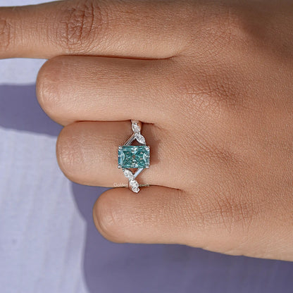 Sterling silver ring with teal emerald-cut stone and small side stones on band