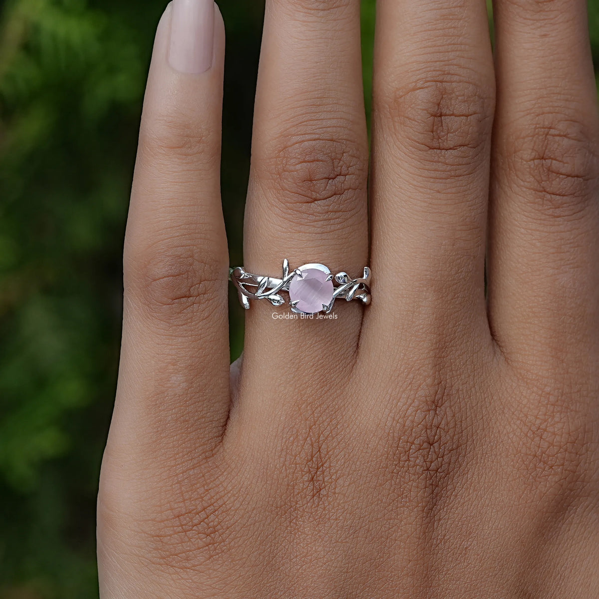 Rose quartz gemstone leaf ring, silver band with side details on hand