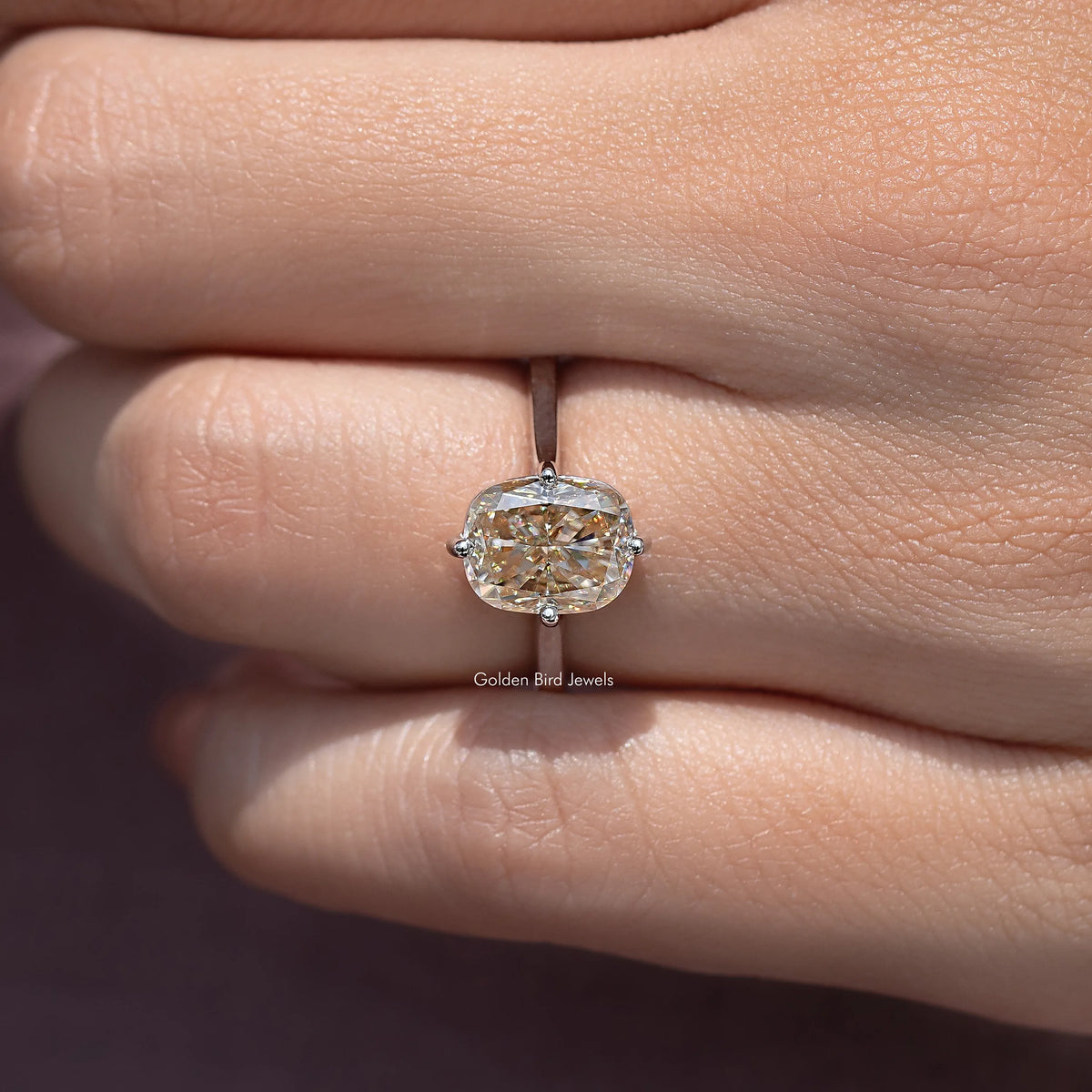 Close-up of rose-gold tone elongated cushion-cut solitaire engagement ring, four prongs