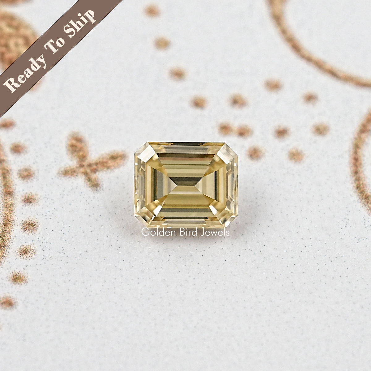 Yellow emerald-cut moissanite gemstone in a rectangular frame, front view, centered.